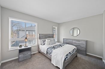 A bedroom with a large bed and a window overlooking a cityscape.